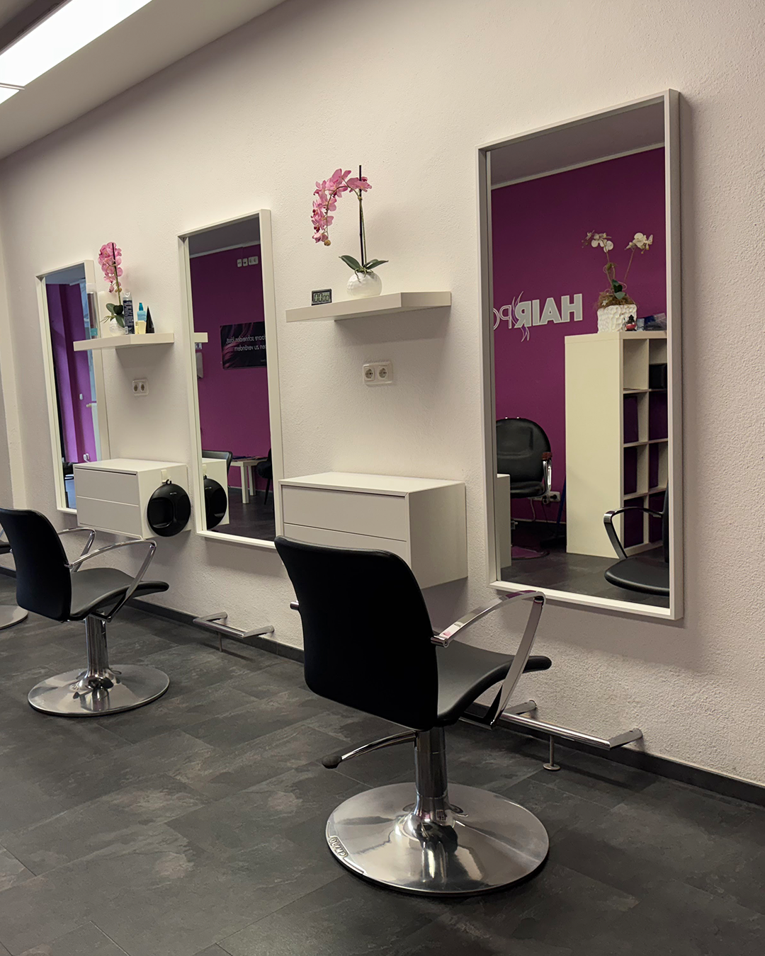 Saloninneneinrichtung mit Spiegeln und Stühlen – Kundenbereich im Hairport Oberhausen